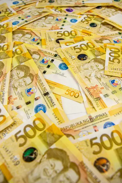 Peso banknotes representing staged remittance for a Davao house build