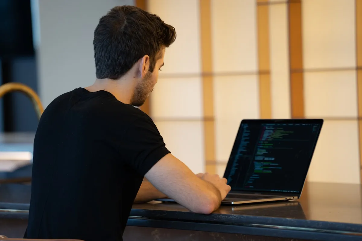 Remote worker typing code on a laptop at a counter in Davao