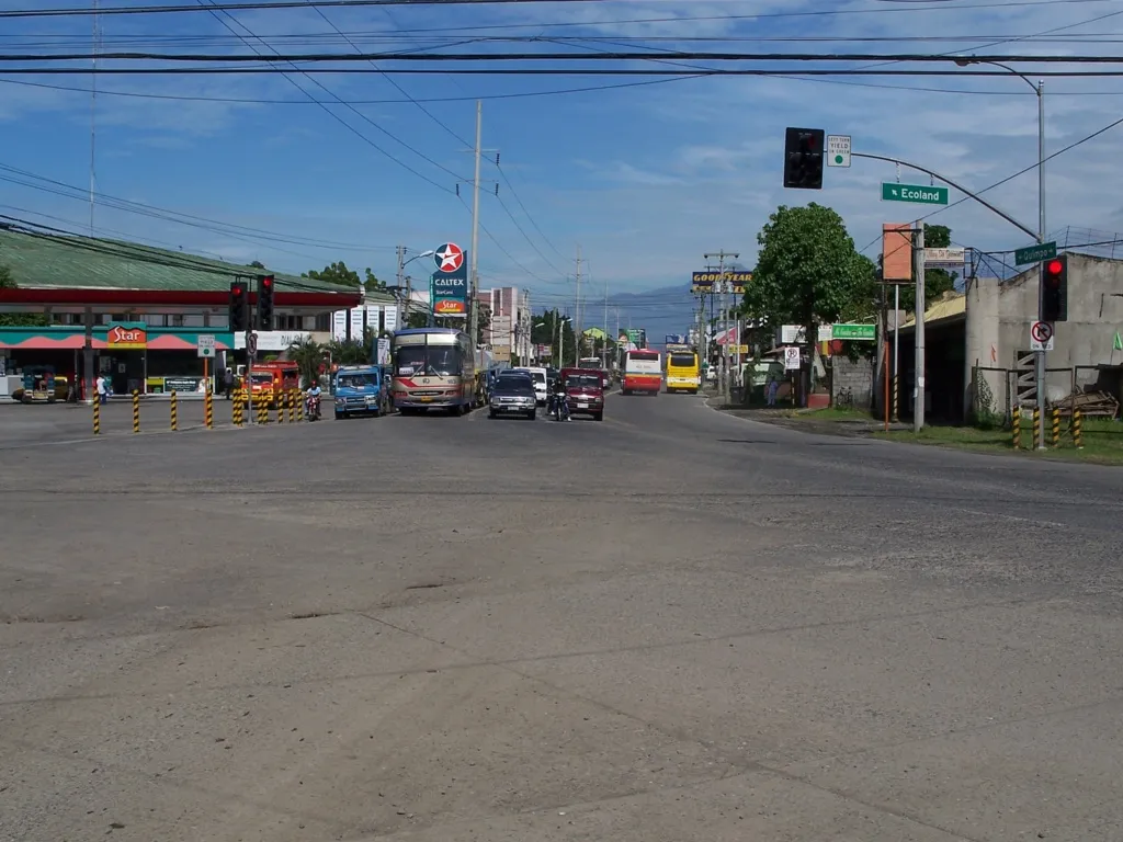 Quimpo Boulevard at Ecoland junction with buses, jeepneys, and a Caltex station — a typical budget-rental commute corridor in Davao