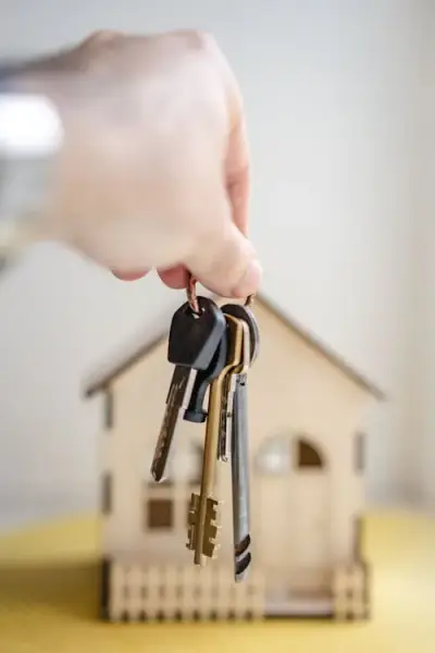 Person holding apartment keys outside a rental unit